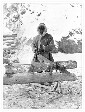 A man in parka sawing wood